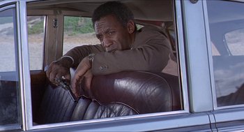 Movie still from “Hickey & Boggs” (1972), directed by Robert Culp – A man sitting in the back seat of a car; Medium shot, Low angle