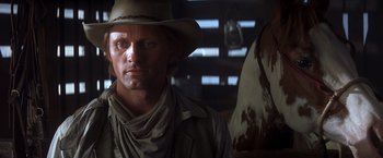 Movie still from “Hidalgo” (2004), directed by Joe Johnston – A man wearing a cowboy hat in a barn; Close Up shot, Over the shoulder angle