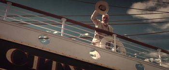 Movie still from “Hidalgo” (2004), directed by Joe Johnston – An older man standing on a balcony holding a hat; Medium shot, Low angle