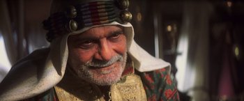 Movie still from “Hidalgo” (2004), directed by Joe Johnston – An older man with a beard wearing a hat; Close Up shot, Over the shoulder angle