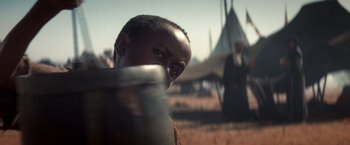 Movie still from “Hidalgo” (2004), directed by Joe Johnston – An african american man with an umbrella in front of an indian village; Close Up shot, Over the shoulder angle