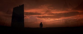 Movie still from “Hidalgo” (2004), directed by Joe Johnston – A man standing in front of a red cloudy sky at night; Wide shot, Low angle