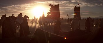 Movie still from “Hidalgo” (2004), directed by Joe Johnston – A group of people standing on top of a sandy beach; Extreme Wide shot, Low angle