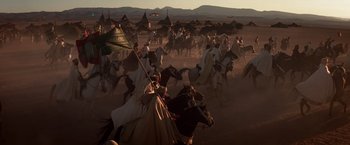 Movie still from “Hidalgo” (2004), directed by Joe Johnston – A group of people riding on the backs of horses; Extreme Wide shot, High angle