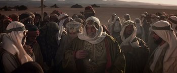 Movie still from “Hidalgo” (2004), directed by Joe Johnston – A group of men in traditional clothing walking through a field; Medium shot, High angle