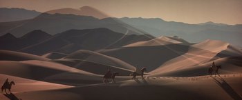 Movie still from “Hidalgo” (2004), directed by Joe Johnston – Two people riding horses in the desert at sunset; Extreme Wide shot, Low angle