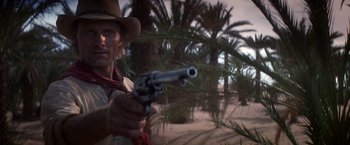 Movie still from “Hidalgo” (2004), directed by Joe Johnston – A man in a cowboy hat holding a gun in the desert; Close Up shot, Low angle