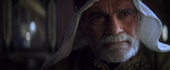 Movie still from “Hidalgo” (2004), directed by Joe Johnston – An old man with a beard and a white head covering; Close Up shot, Over the shoulder angle