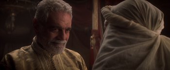Movie still from “Hidalgo” (2004), directed by Joe Johnston – An older man with a white beard is looking at the camera; Close Up shot, Over the shoulder angle