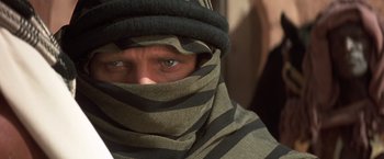 Movie still from “Hidalgo” (2004), directed by Joe Johnston – A man with a scarf covering his face and wearing a hat; Close Up shot, Over the shoulder angle