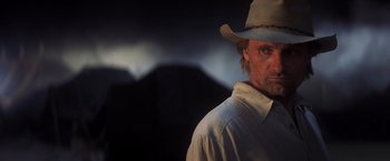 Movie still from “Hidalgo” (2004), directed by Joe Johnston – A man wearing a cowboy hat standing in front of mountains; Close Up shot, Low angle