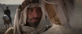 Movie still from “Hidalgo” (2004), directed by Joe Johnston – A man with a beard wearing a head scarf; Close Up shot, Over the shoulder angle