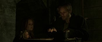 Movie still from “Hidden” (2015), directed by Ross Duffer – A man and a little girl playing a game on a computer keyboard; Close Up shot, Over the shoulder angle