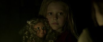 Movie still from “Hidden” (2015), directed by Ross Duffer – A young girl holding a creepy doll in a dark room; Close Up shot, Over the shoulder angle