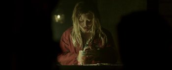 Movie still from “Hidden” (2015), directed by Ross Duffer – A woman is looking at her cell phone while sitting at a table; Close Up shot, Over the shoulder angle