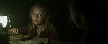 Movie still from “Hidden” (2015), directed by Ross Duffer – A little girl sitting at a table looking at the camera; Close Up shot, Over the shoulder angle