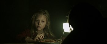 Movie still from “Hidden” (2015), directed by Ross Duffer – A young girl sitting in front of a bowl of food; Close Up shot, Over the shoulder angle
