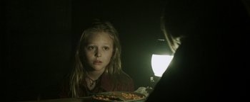 Movie still from “Hidden” (2015), directed by Ross Duffer – A young girl sitting at a table with a plate of food; Close Up shot, Over the shoulder angle