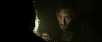 Movie still from “Hidden” (2015), directed by Ross Duffer – A man with long hair and a goatee looking in a mirror; Close Up shot, Over the shoulder angle