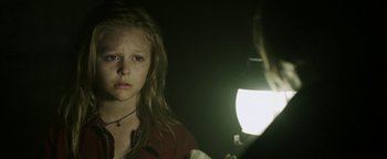 Movie still from “Hidden” (2015), directed by Ross Duffer – A young girl is being photographed by a photographer; Close Up shot, Over the shoulder angle