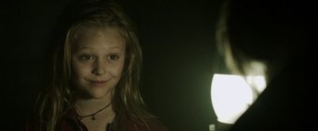 Movie still from “Hidden” (2015), directed by Ross Duffer – A young girl is smiling for the camera; Close Up shot, Over the shoulder angle