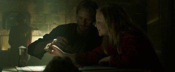 Movie still from “Hidden” (2015), directed by Ross Duffer – A man and a girl looking at a cell phone; Close Up shot, Over the shoulder angle