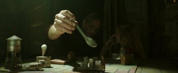 Movie still from “Hidden” (2015), directed by Ross Duffer – A man holding a wooden spoon in front of a table; Close Up shot, Over the shoulder angle