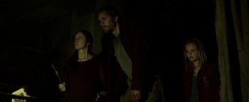 Movie still from “Hidden” (2015), directed by Ross Duffer – A man and a woman standing next to each other in the dark; Medium shot, Low angle