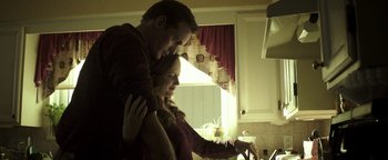 Movie still from “Hidden” (2015), directed by Ross Duffer – A man and a woman are looking at a laptop; Medium shot, Low angle