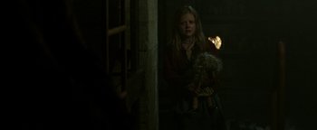 Movie still from “Hidden” (2015), directed by Ross Duffer – A young girl holding a doll in a dark room; Medium shot, Over the shoulder angle