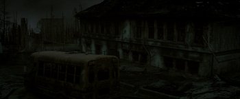 Movie still from “Hidden” (2015), directed by Ross Duffer – An old bus parked in front of an abandoned building; Extreme Wide shot, High angle