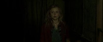 Movie still from “Hidden” (2015), directed by Ross Duffer – A young girl is standing in a dark room; Close Up shot, Low angle