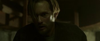 Movie still from “Hidden” (2015), directed by Ross Duffer – A person with long blonde hair; Close Up shot, Low angle