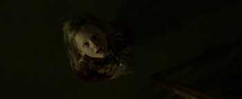 Movie still from “Hidden” (2015), directed by Ross Duffer – A young girl is looking up at the camera; Close Up shot, Overhead angle