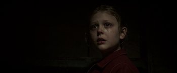 Movie still from “Hidden” (2015), directed by Ross Duffer – A young girl crying in a dark room; Close Up shot, Low angle