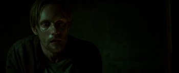 Movie still from “Hidden” (2015), directed by Ross Duffer – A man in a dark room looking at the camera; Close Up shot, High angle