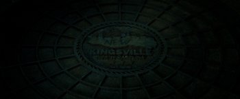 Movie still from “Hidden” (2015), directed by Ross Duffer – View of a sign on the side of a building; Extreme Close Up shot, Overhead angle