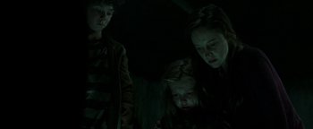 Movie still from “Hidden” (2015), directed by Ross Duffer – A group of people standing next to each other in the dark; Medium shot, Low angle