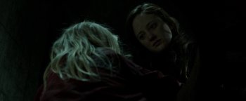 Movie still from “Hidden” (2015), directed by Ross Duffer – A woman looking in the mirror while another woman looks on; Close Up shot, Over the shoulder angle