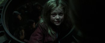 Movie still from “Hidden” (2015), directed by Ross Duffer – A young girl with long blonde hair is looking at the camera; Close Up shot, Over the shoulder angle