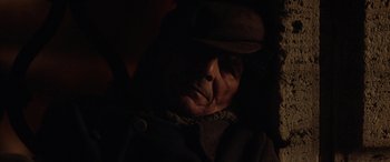 Movie still from “Hidden Away” (2020), directed by Giorgio Diritti – An old man wearing a hat in the dark; Close Up shot, Over the shoulder angle