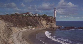 Movie still from “High Anxiety” (1977), directed by Mel Brooks – A lighthouse on the side of a cliff overlooking the ocean; Extreme Wide shot, High angle