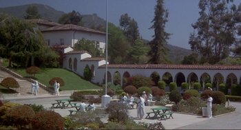 Movie still from “High Anxiety” (1977), directed by Mel Brooks – A group of people standing around a building; Extreme Wide shot, High angle