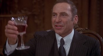 Movie still from “High Anxiety” (1977), directed by Mel Brooks – A man in a suit holding a glass of wine; Close Up shot, Low angle