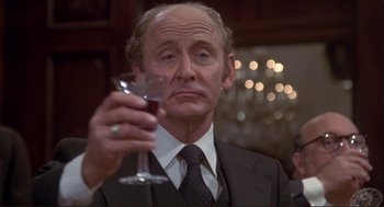 Movie still from “High Anxiety” (1977), directed by Mel Brooks – An older man holding a glass of wine in his hand; Close Up shot, Low angle