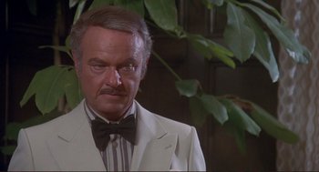 Movie still from “High Anxiety” (1977), directed by Mel Brooks – A man in a white suit and bow tie; Close Up shot, High angle