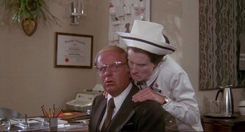 Movie still from “High Anxiety” (1977), directed by Mel Brooks – A man and a woman are sitting at a desk; Medium shot, Over the shoulder angle
