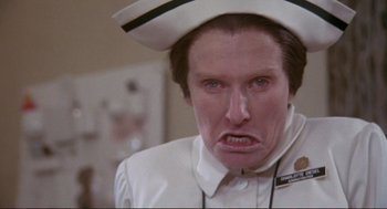 Movie still from “High Anxiety” (1977), directed by Mel Brooks – A man in a nurse's uniform with a frowning look on his face; Close Up shot, Low angle