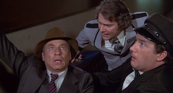 Movie still from “High Anxiety” (1977), directed by Mel Brooks – A man in a suit and a hat looking at another man in a suit and a hat; Medium shot, High angle