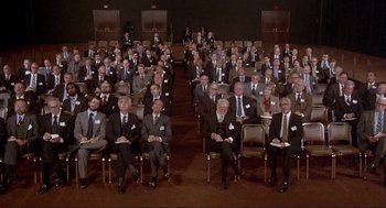 Movie still from “High Anxiety” (1977), directed by Mel Brooks – A large group of men in suits and ties sitting in chairs; Wide shot, High angle